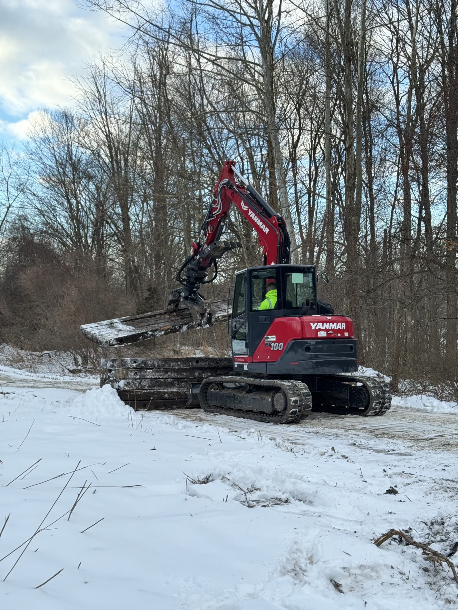 Excavator operated by Tidy Services grabbing debris in Burlington, CT
