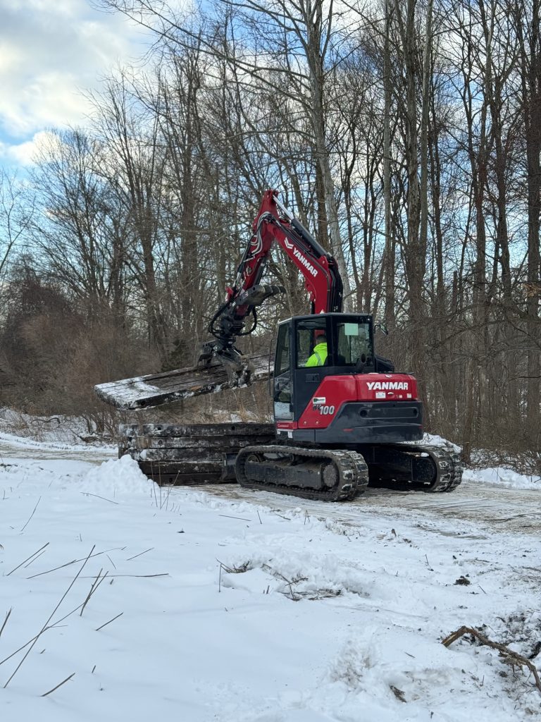 Excavator operated by Tidy Services grabbing debris in Burlington, CT